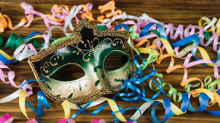 Photo gratuit gros plan d'un masque de carnaval avec des banderoles colorées sur un bureau en bois