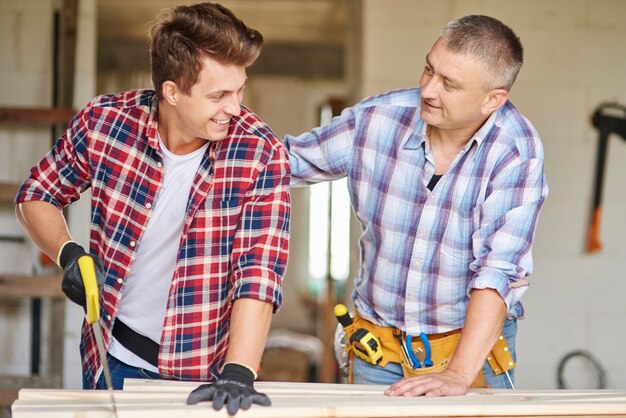 Gros plan sur un menuisier expérimenté et son jeune employé