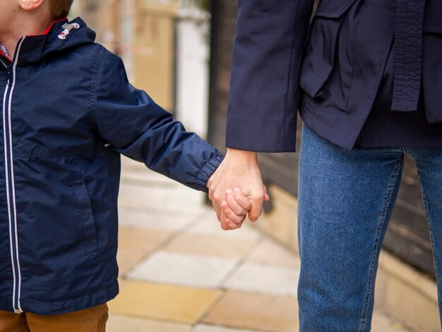 Gros plan, mère fils, tenant mains