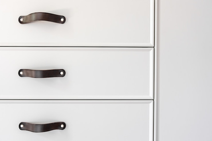 Photo gratuit gros plan sur des meubles blancs minimalistes avec poignées noires, armoires de cuisine, détails.