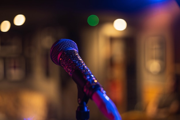 Gros plan d'un microphone sur un espace flou avec des lumières bokeh