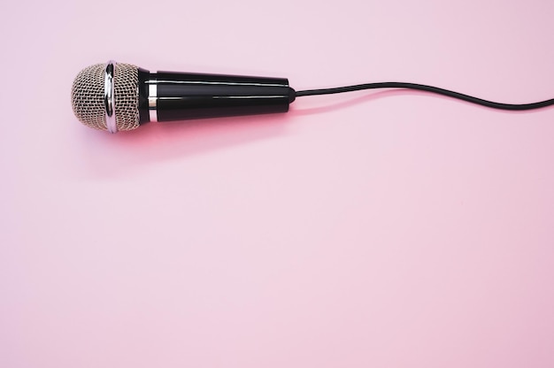 Photo gratuite gros plan d'un microphone avec un fil isolé sur un fond rose avec une ombre