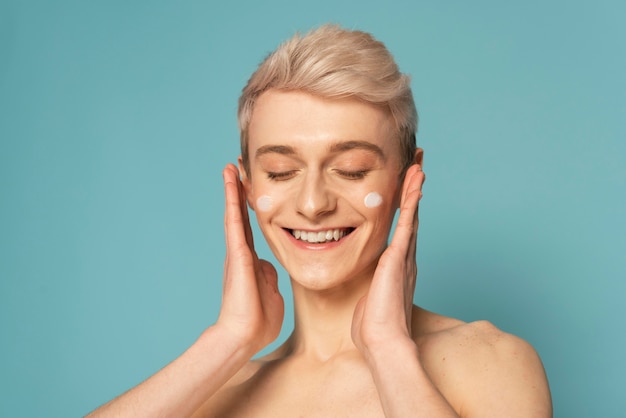 Gros plan modèle smiley avec crème pour le visage