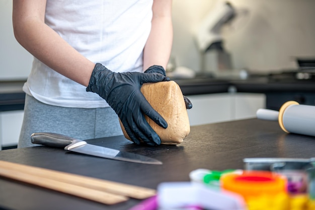 Gros plan sur un morceau de pâte dans des mains féminines travaillant avec de la pâte