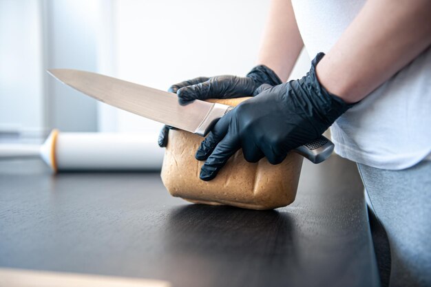 Gros plan sur un morceau de pâte dans des mains féminines travaillant avec de la pâte