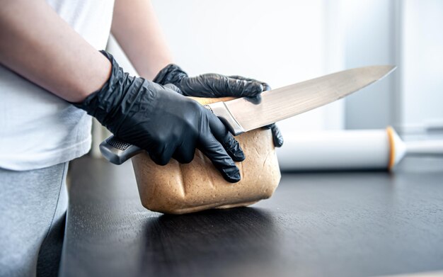 Gros plan sur un morceau de pâte dans des mains féminines travaillant avec de la pâte