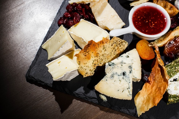 Gros plan de morceaux de fromage bleu et de camembert couché sur plaque noire