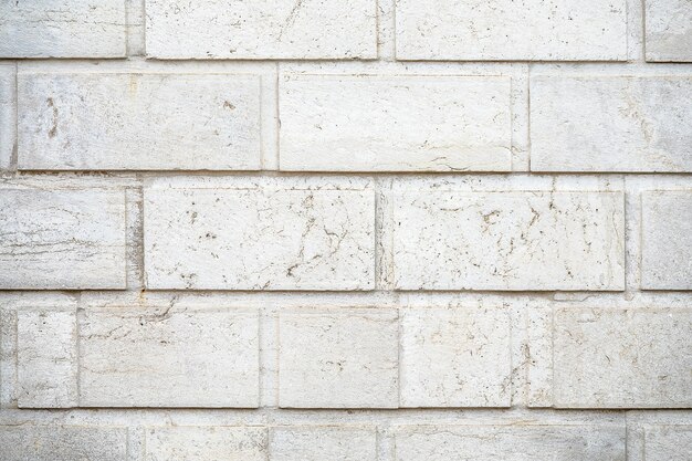 Gros plan d'un mur fait de fond de pierres rectangulaires blanches