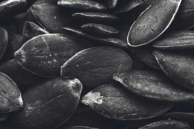 Gros plan en niveaux de gris d'un grand nombre de graines de citrouille - idéal pour un fond noir et blanc