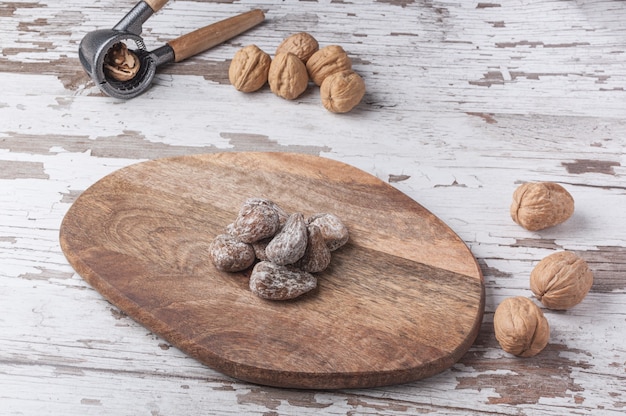 Gros plan de noix, casse-noisette et fruits secs sur une planche de bois