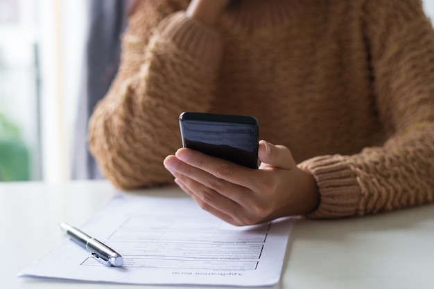 Gros plan, occupé, dame, remplissage, document, et, vérification, sms, sur, téléphone