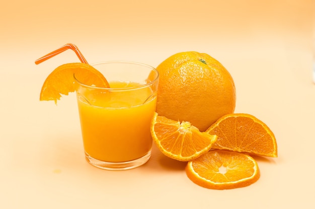 Gros plan d'oranges en tranches et un verre avec du jus d'orange