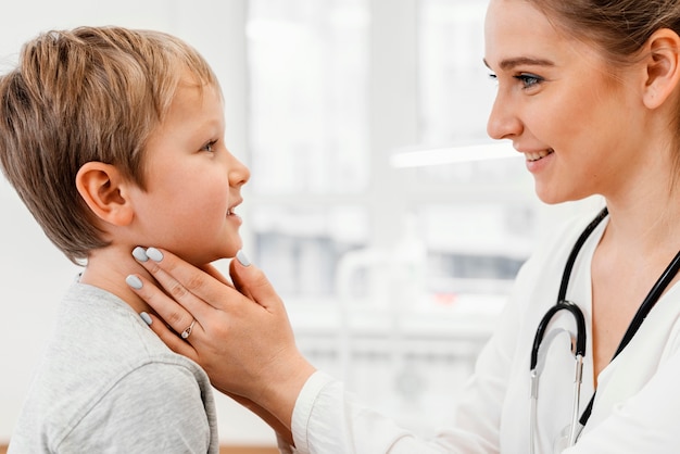 Photo gratuite gros plan pédiatre vérifiant le cou