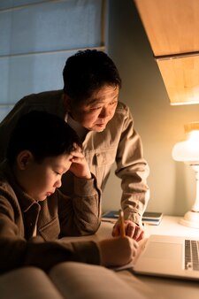 Gros plan père aidant un enfant à faire ses devoirs