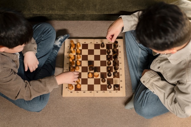 Gros plan père et garçon jouant aux échecs