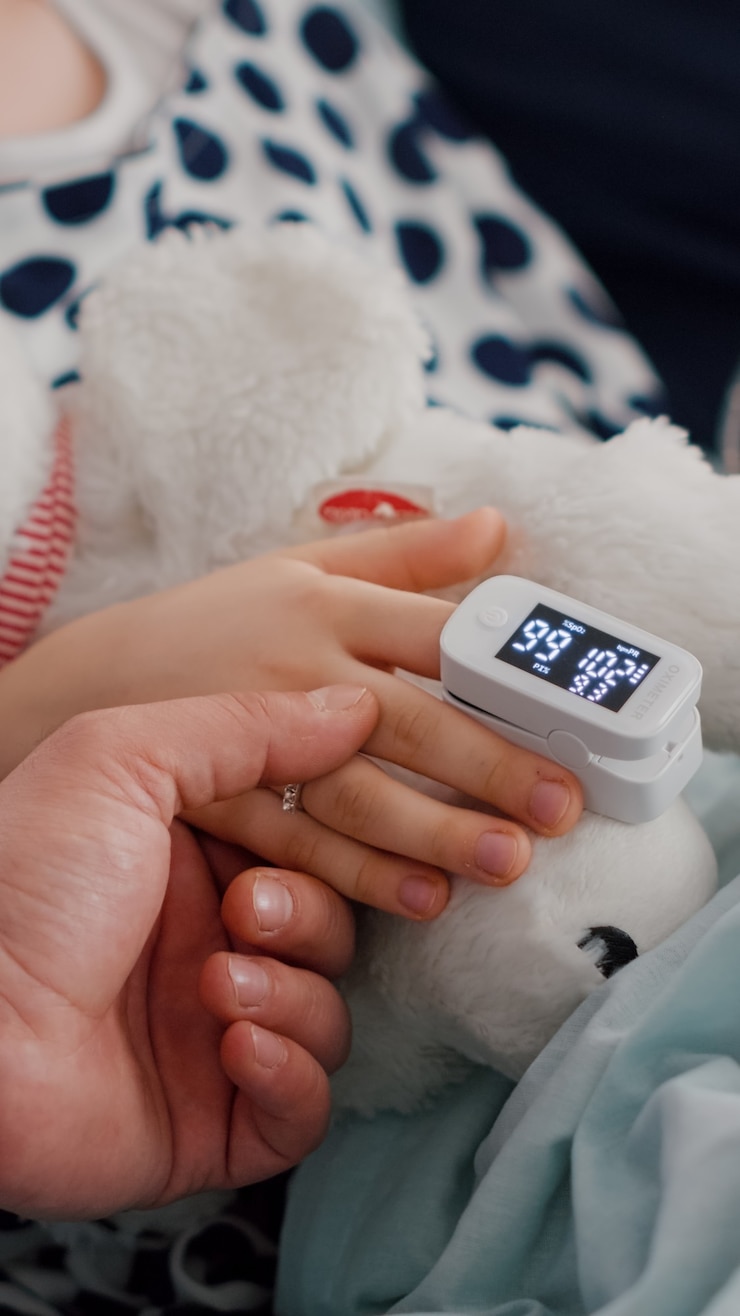 Photo gratuit gros plan sur un père tenant les mains d'une fille malade après avoir subi une intervention chirurgicale contre une infection par la maladie lors de l'examen de récupération. fille hospitalisée se reposant dans le lit avec l'oxymètre de médecine sur le doigt