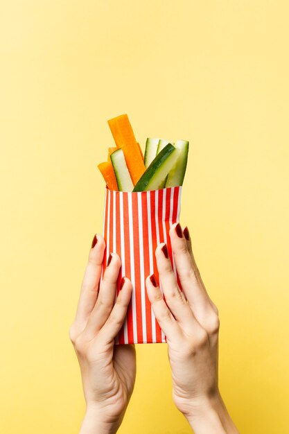 Gros plan personne brandissant des légumes