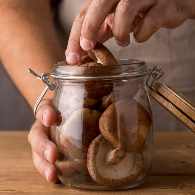 Gros plan, de, personne, mettre, champignons, dans verre bocal