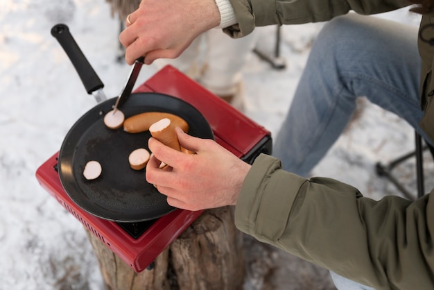 Gros plan sur une personne préparant de la nourriture en camping