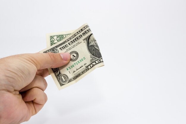 Gros plan d'une personne tenant un billet d'un dollar sur un fond blanc