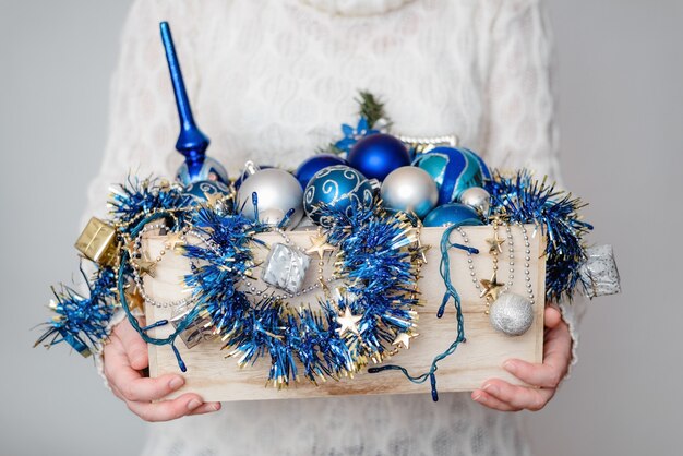 Gros plan d'une personne tenant une boîte de décorations de Noël