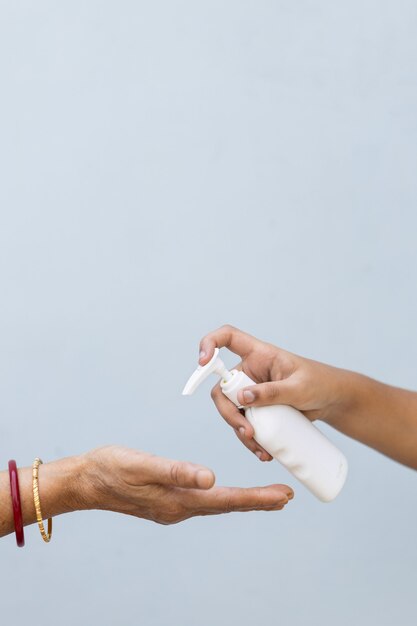 Gros Plan D'une Personne Versant Du Savon Liquide Dans La Main D'une Autre Personne