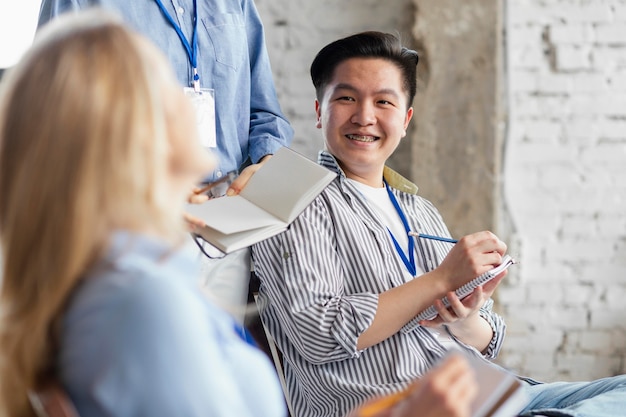 Gros plan des personnes souriantes en prenant des notes