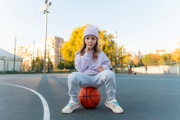 Photo gratuite gros plan sur une petite fille jouant au basket