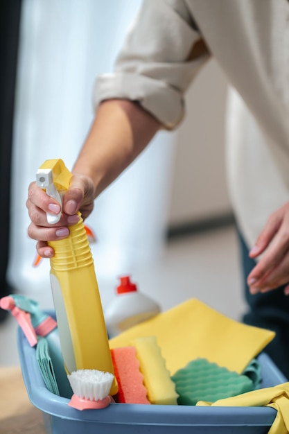 Gros plan photo de mains racontant quelque chose de la boîte avec des produits de nettoyage