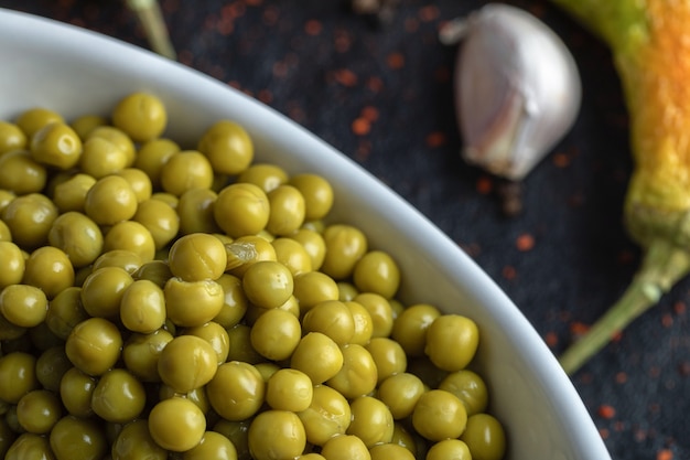 Gros plan photo de tas de petits pois marinés verts.