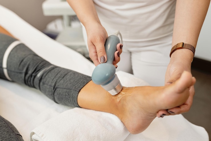 Photo gratuit gros plan d'un physiothérapeute traitant l'articulation du client avec l'électrothérapie
