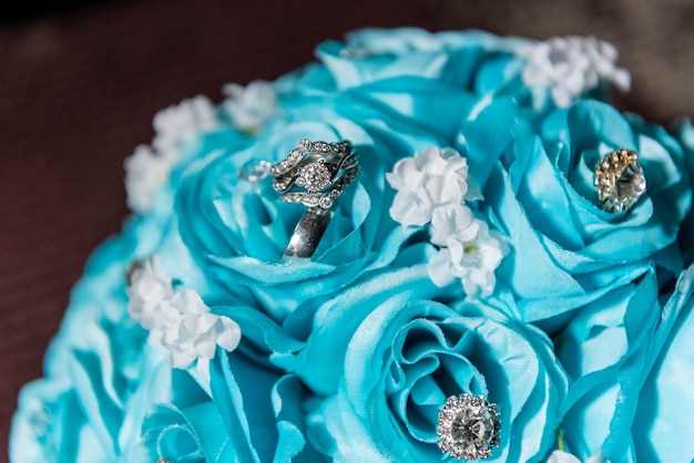 Gros plan de pierres précieuses sur un bouquet de roses bleues