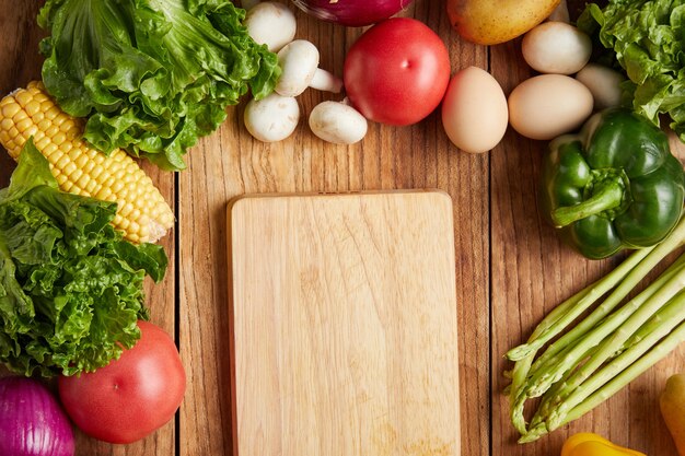 Gros plan sur une planche à découper et des légumes frais sur une surface en bois