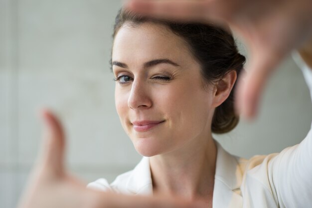 Gros plan Playful Woman Making Cadre et un clin d&#39;oeil