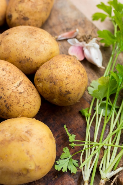 Gros plan de pommes de terre crues sur planche de bois