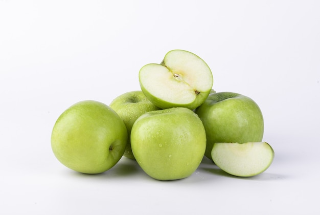 Gros plan de pommes vertes tranchées fraîches isolées sur mur blanc