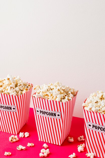 Gros plan, pop-corn, boîtes rayées, bureau rose, contre, mur blanc