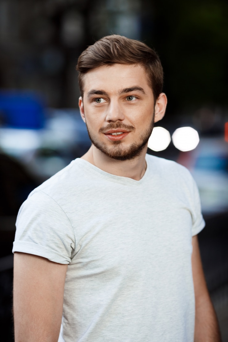 Photo gratuit gros plan le portrait de beau jeune homme confiant en t-shirt blanc à l'écart sur la nature extérieure floue