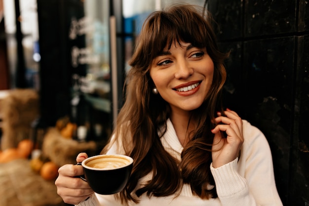 Gros plan portrait de charmante femme brune avec une tasse de café.