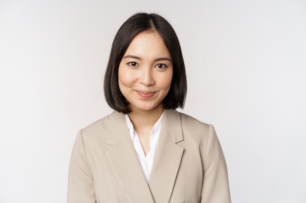Gros plan portrait de femme d'affaires asiatique femme entrepreneur en costume souriant et à la recherche de professionnels debout sur fond blanc