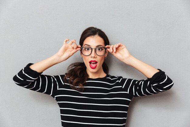 Gros plan le portrait d'une femme choquée à lunettes