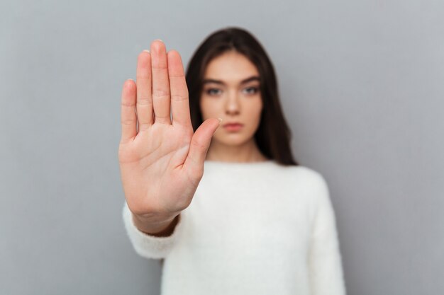 Gros plan le portrait d'une femme montrant le geste d'arrêt