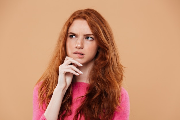 Gros plan le portrait d'une jeune rousse réfléchie