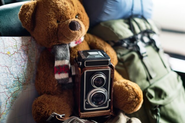 Gros plan d&#39;une poupée ours brun avec appareil photo et carte de voyage