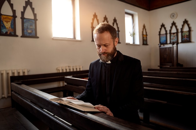 Gros plan sur le prêtre lisant la bible