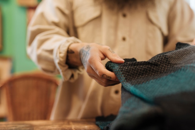 Gros plan d&#39;un propriétaire masculin pliant le sweat shirt