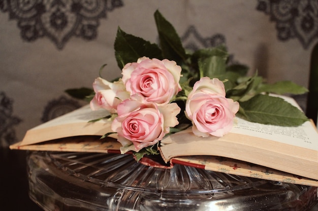 Gros plan de roses roses sur un livre ouvert