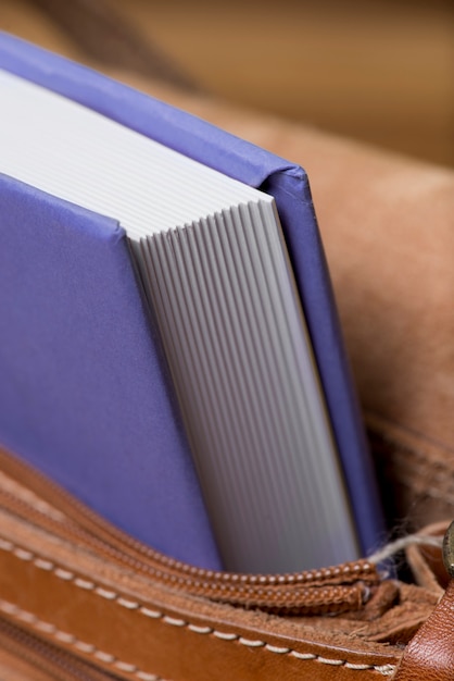 Gros plan sac à main en cuir avec le livre violet