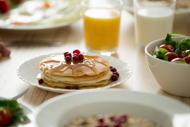 Gros plan de savoureuses crêpes servies avec du sirop et des baies