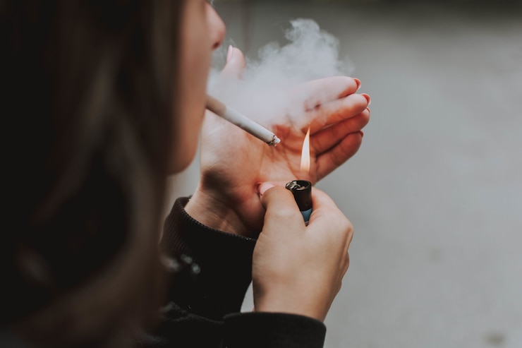Photo gratuit gros plan sélectif d'une femme allumant une cigarette avec un briquet